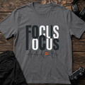 Charcoal gaming T-shirt. Repeated Focus lettering ends in a heartbeat and small controller.