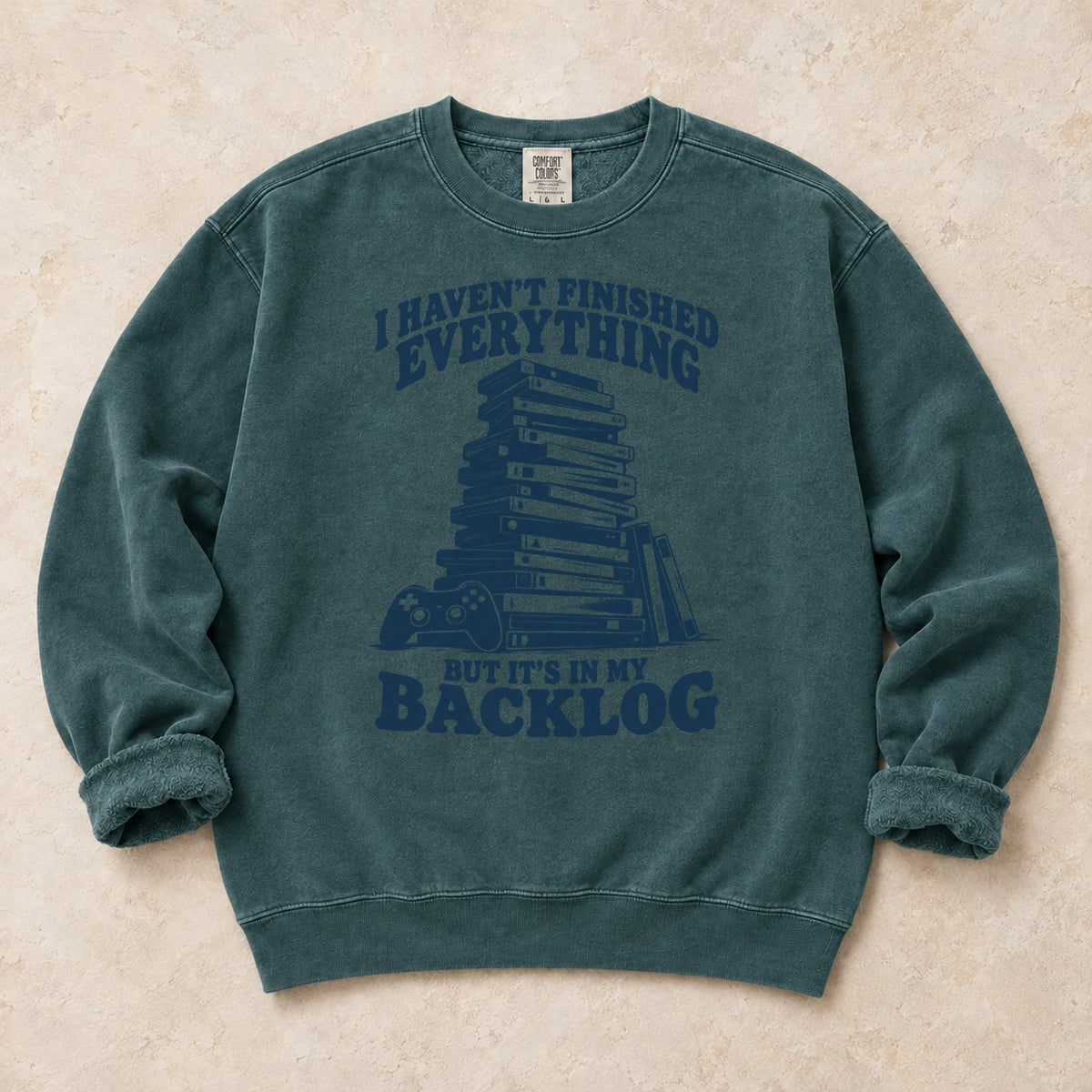 Blue Spruce gaming sweatshirt. A game stack admits everything unfinished is in the backlog.
