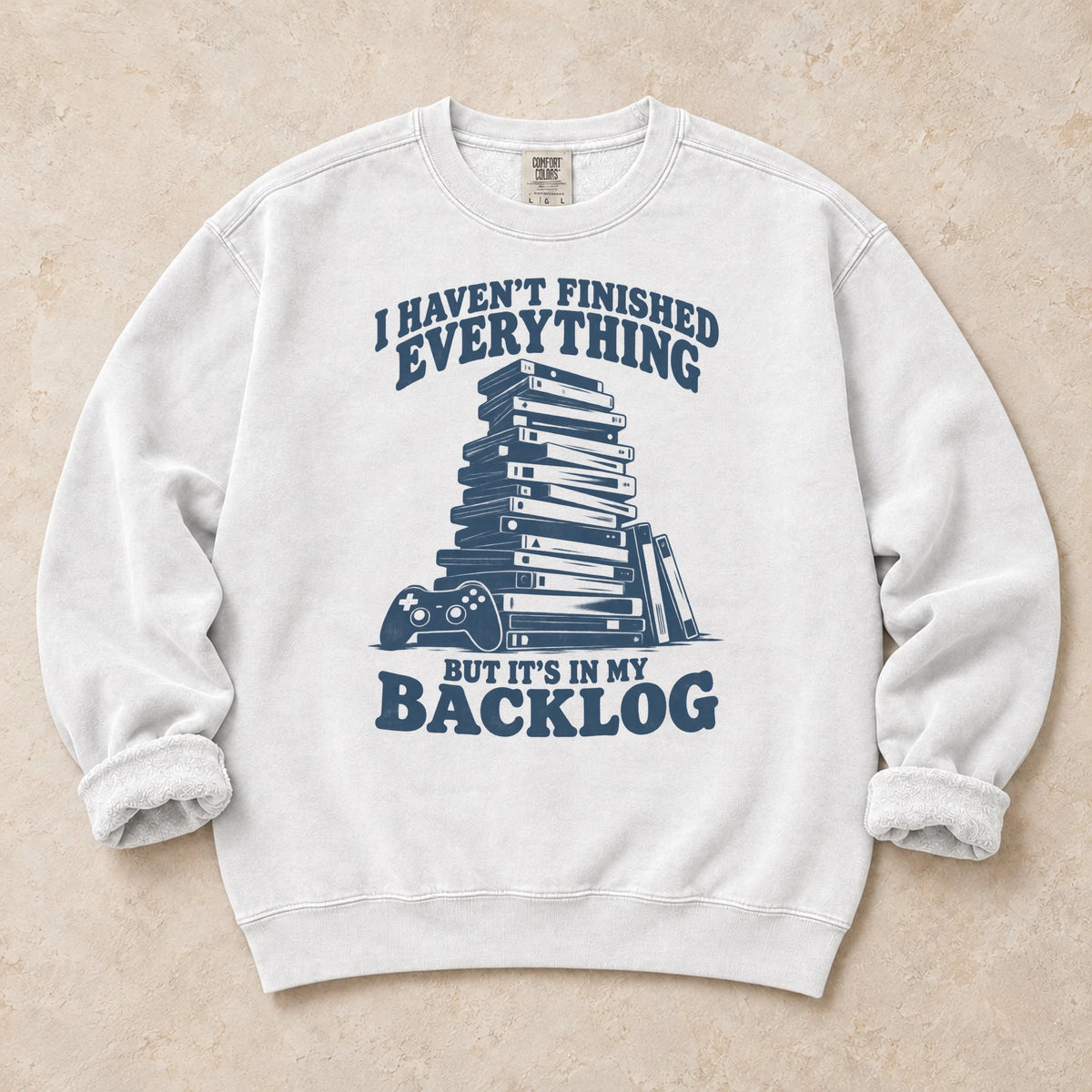 White gaming sweatshirt. A game stack admits everything unfinished is in the backlog.