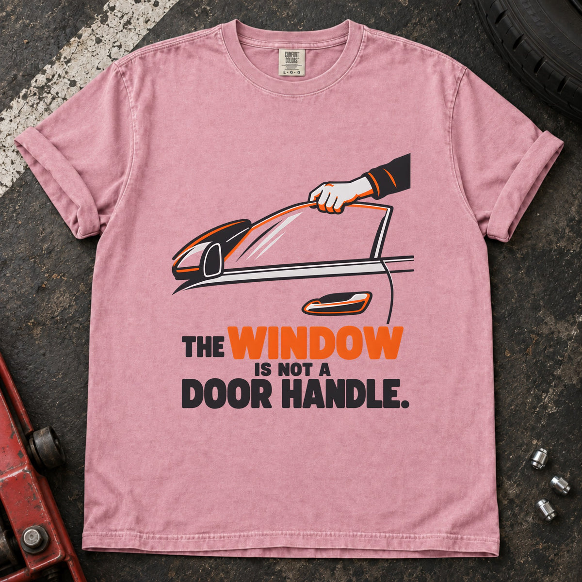 Blossom T-shirt showing a hand reaching through a car window with 'The window is not a door handle'.