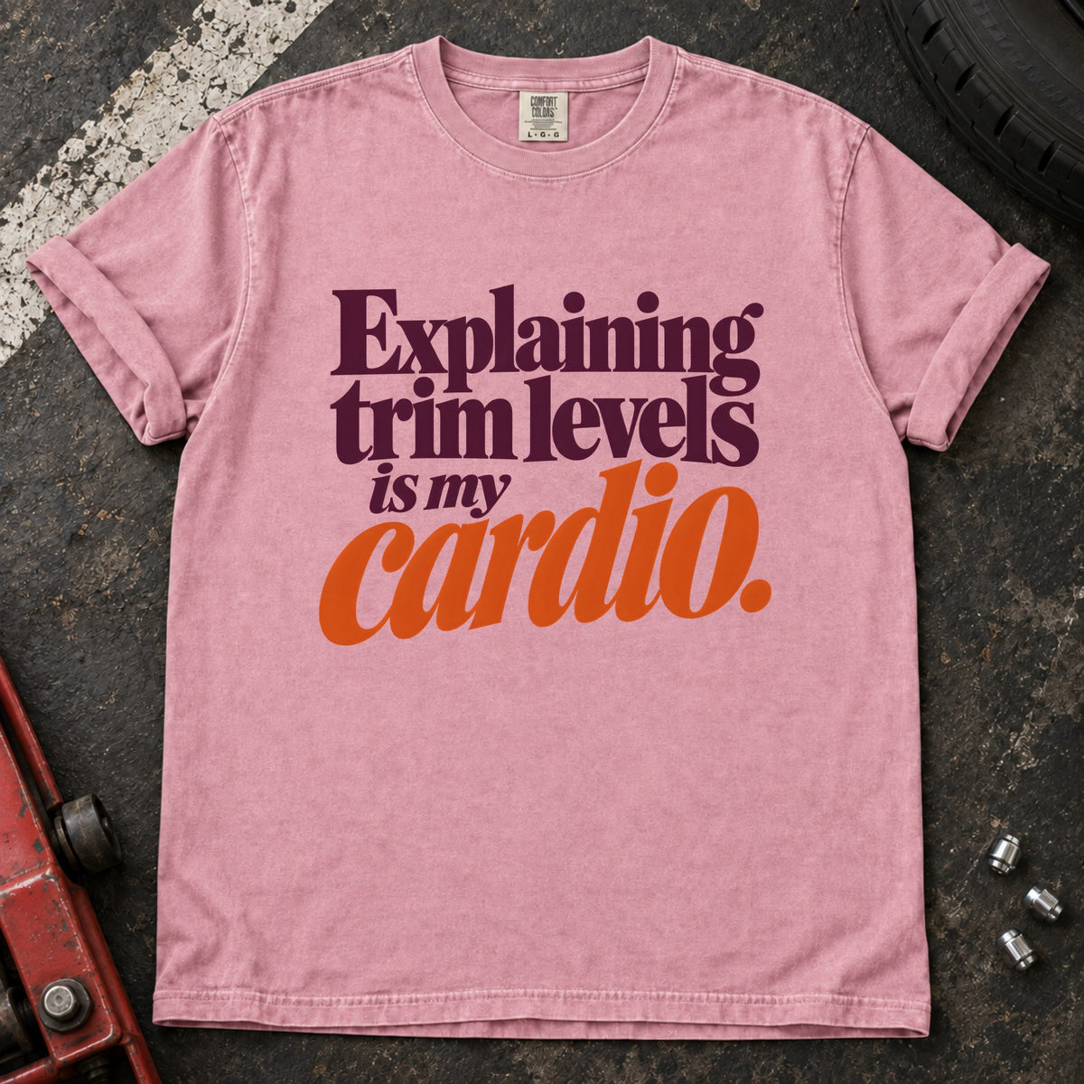 Blossom T-shirt with burgundy and orange lettering reading 'Explaining trim levels is my cardio'.