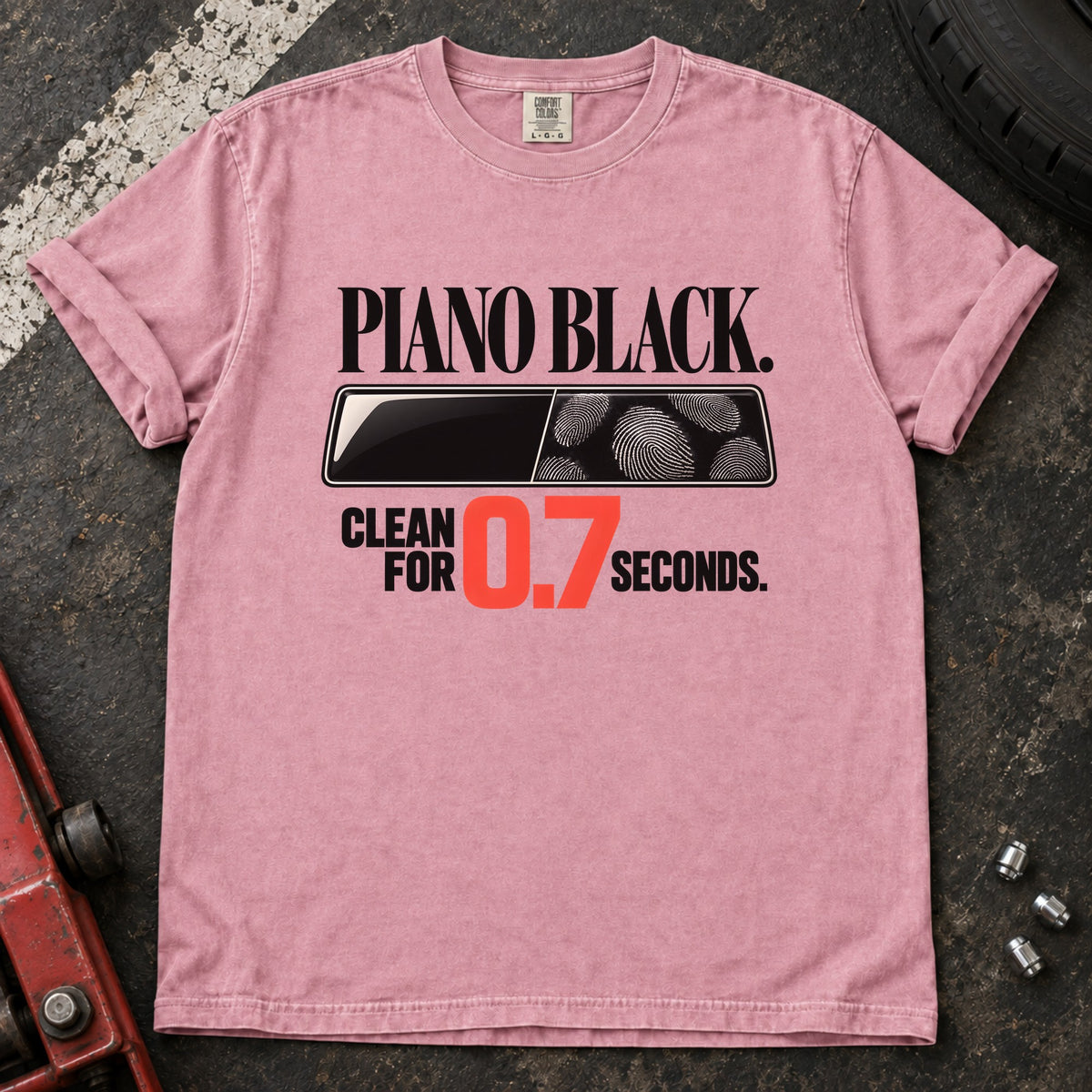 Blossom T-shirt showing fingerprints on a trim panel with 'Piano black. Clean for 0.7 seconds'.