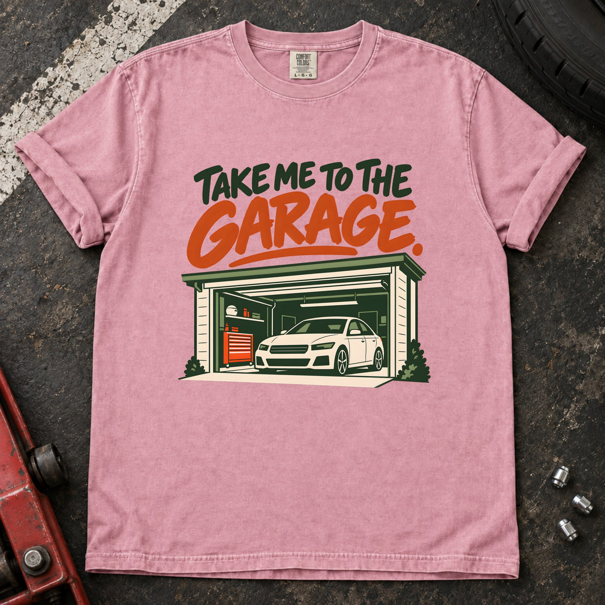 Blossom T-shirt showing a car inside a garage beneath green and orange 'Take me to the garage' lettering.