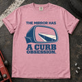 Blossom T-shirt showing a side mirror reflecting a curb with 'The mirror has a curb obsession'.
