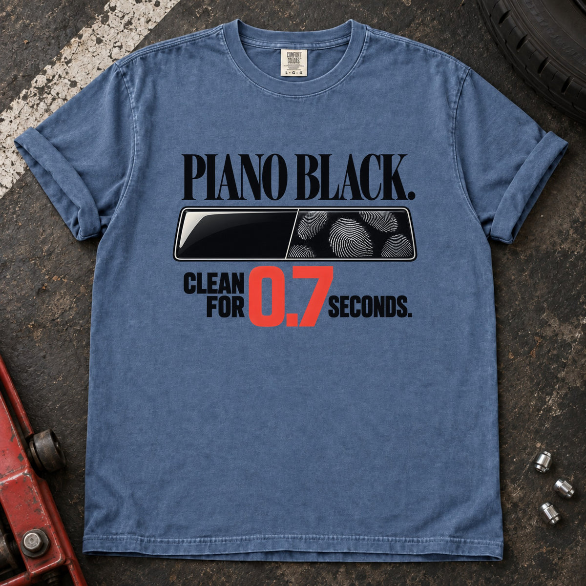 Blue Jean T-shirt showing fingerprints on a trim panel with 'Piano black. Clean for 0.7 seconds'.
