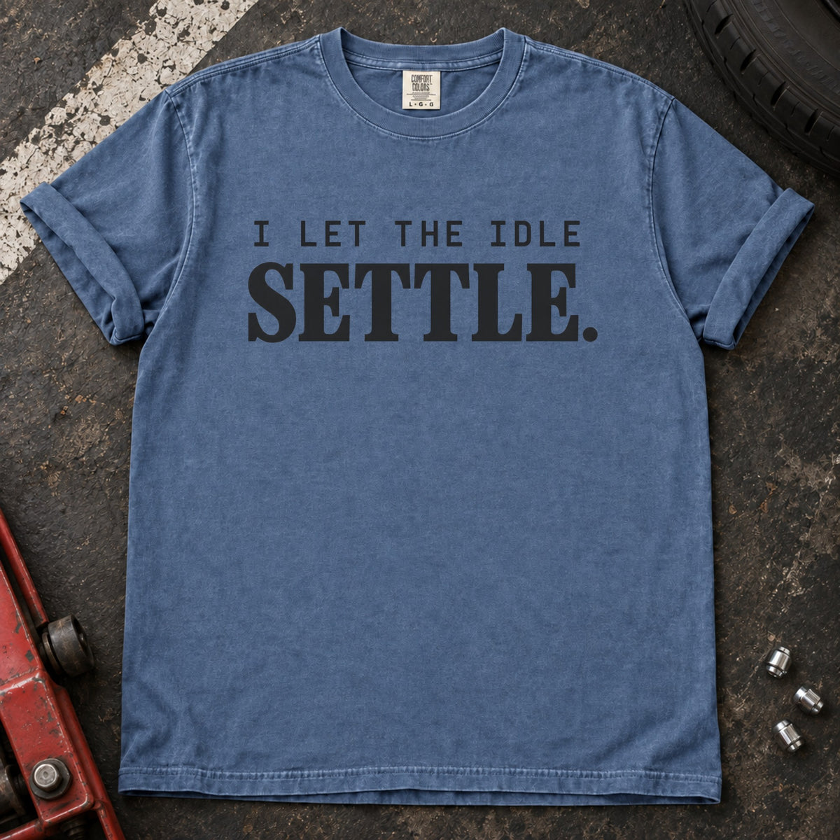 Blue Jean T-shirt with spaced lettering reading 'I let the idle settle'.