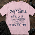 Light Pink gaming T-shirt. A castle, house keys and lease contrast fantasy ownership with real rent.