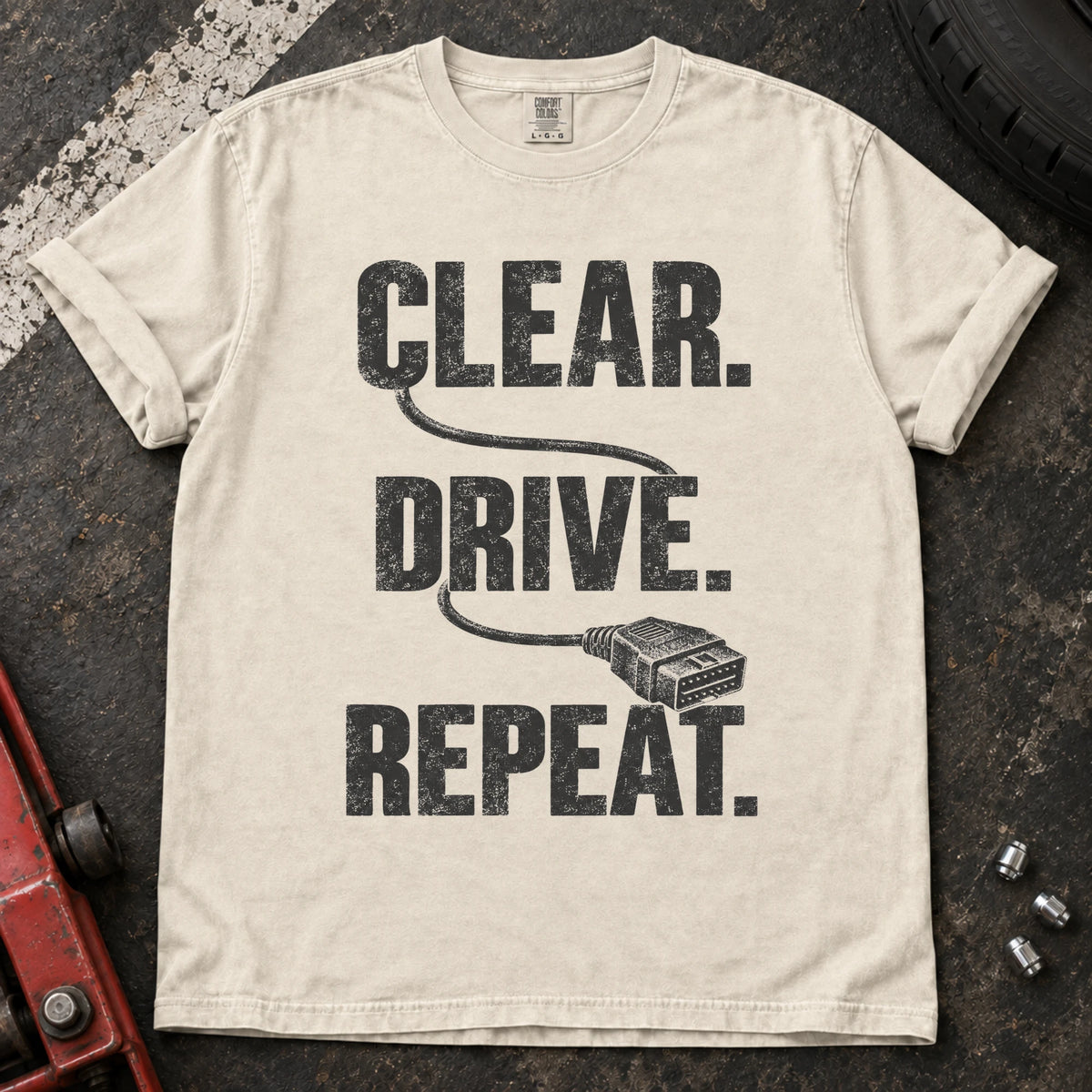 Ivory car enthusiast T-shirt. A diagnostic cable connects clear, drive, repeat.
