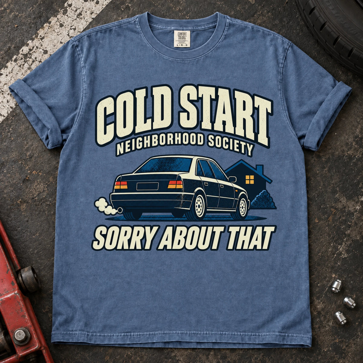 Blue Jean car enthusiast T-shirt. A car outside a house apologizes for the Cold Start Neighborhood Society.