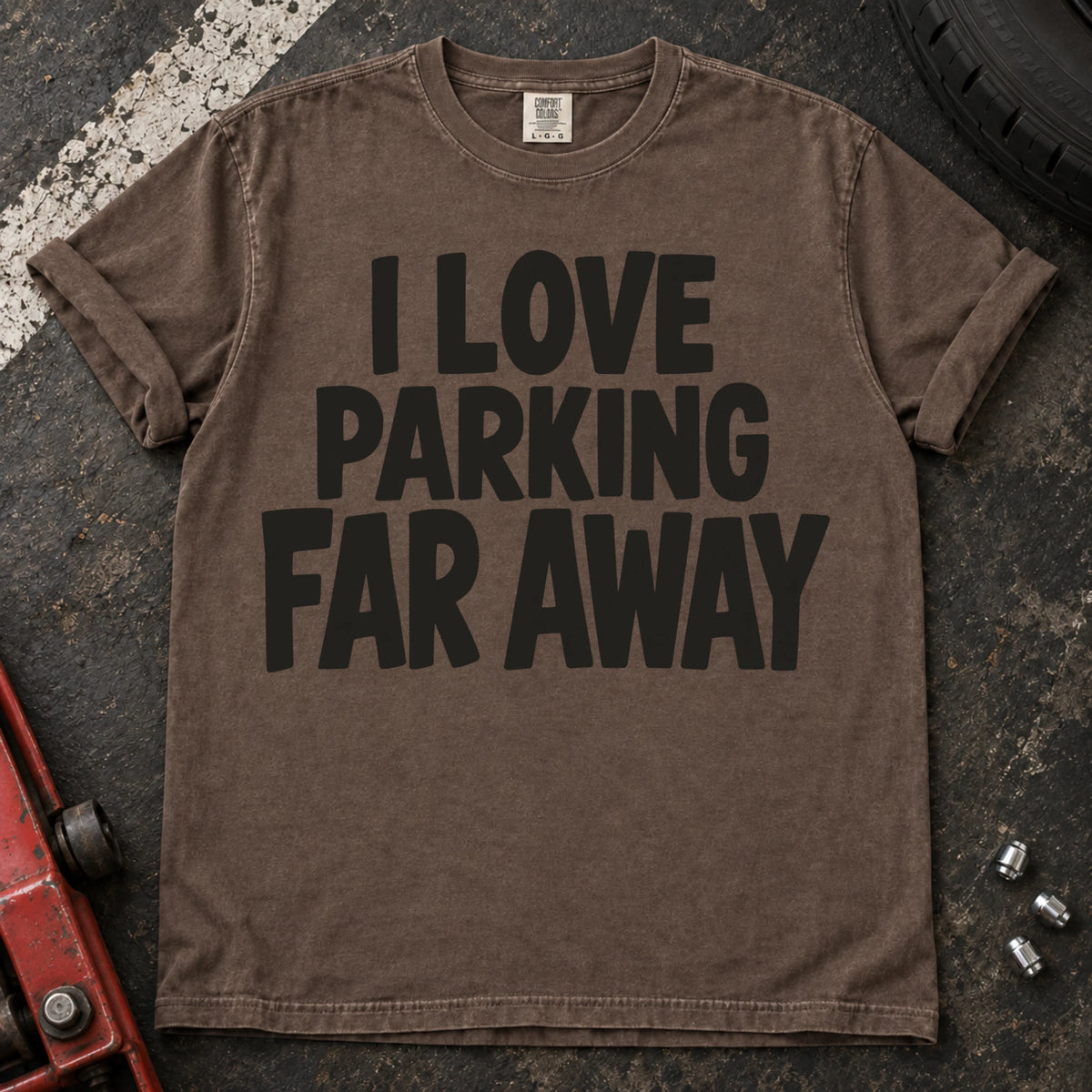 Espresso T-shirt with bold stacked lettering reading 'I love parking far away'.