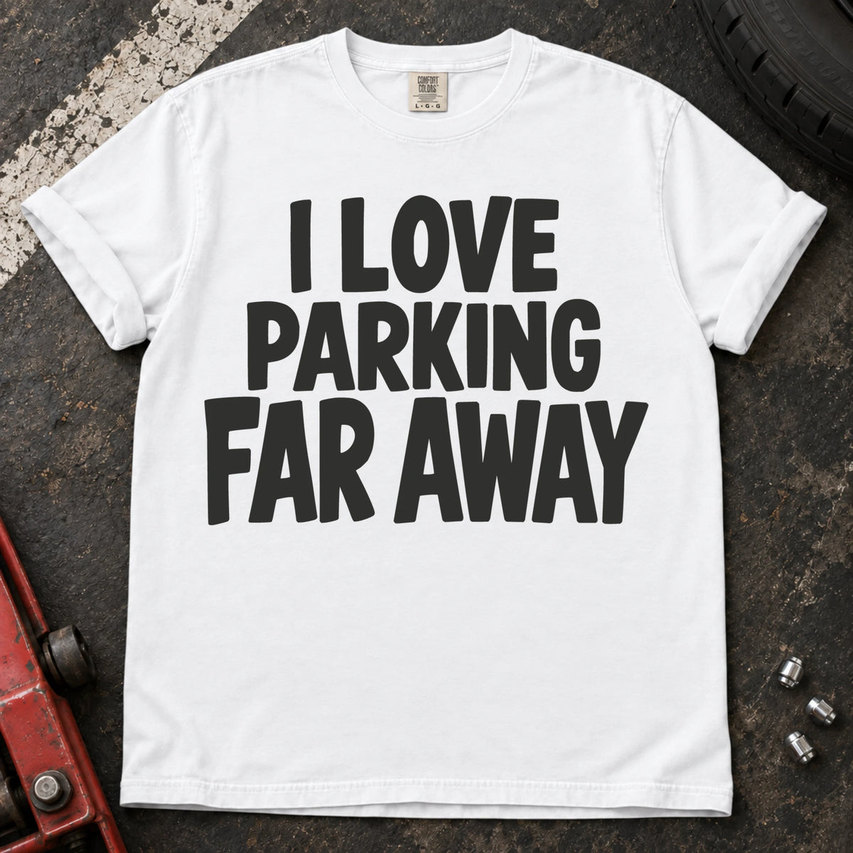 White T-shirt with bold stacked lettering reading 'I love parking far away'.