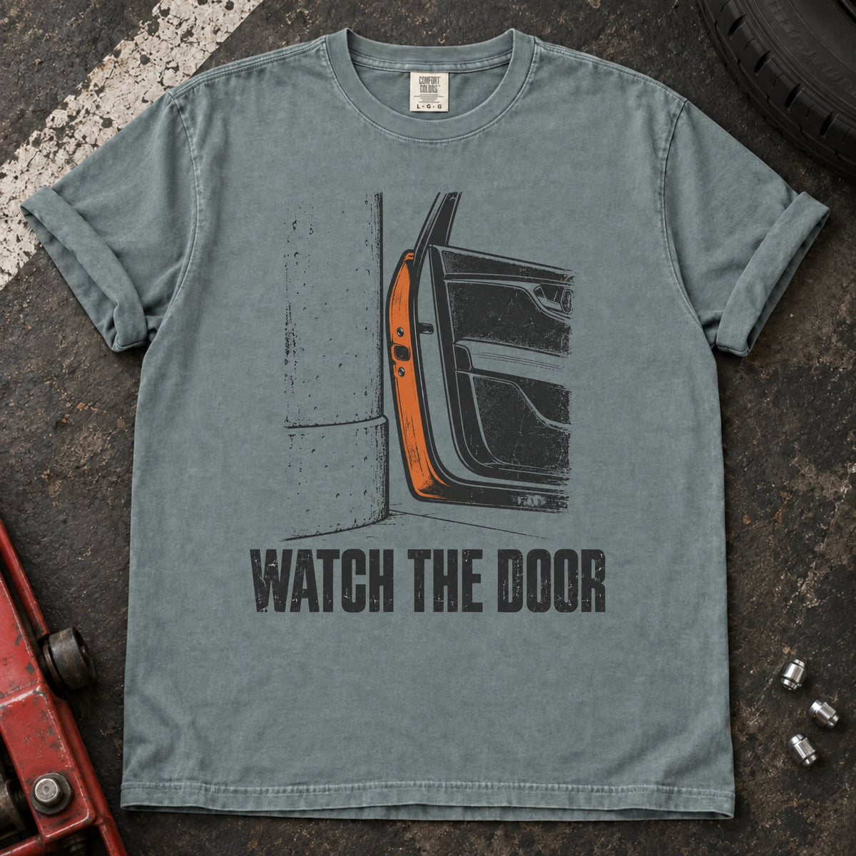 Bay car enthusiast T-shirt. A car door beside a wall makes watch the door an enthusiast's warning.