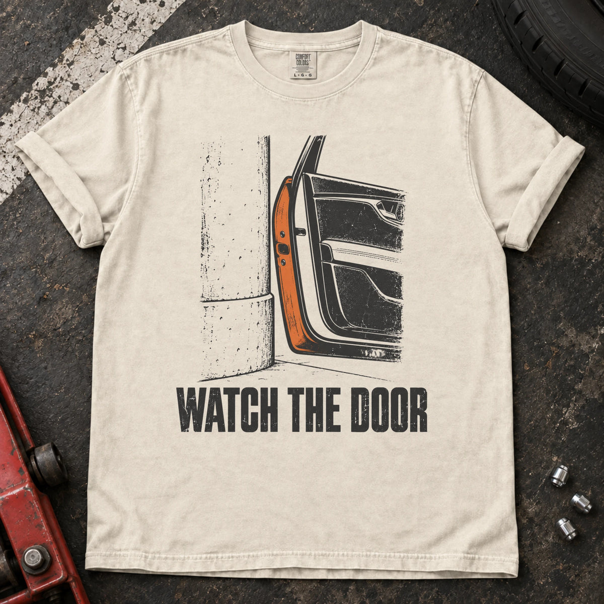 Ivory car enthusiast T-shirt. A car door beside a wall makes watch the door an enthusiast's warning.