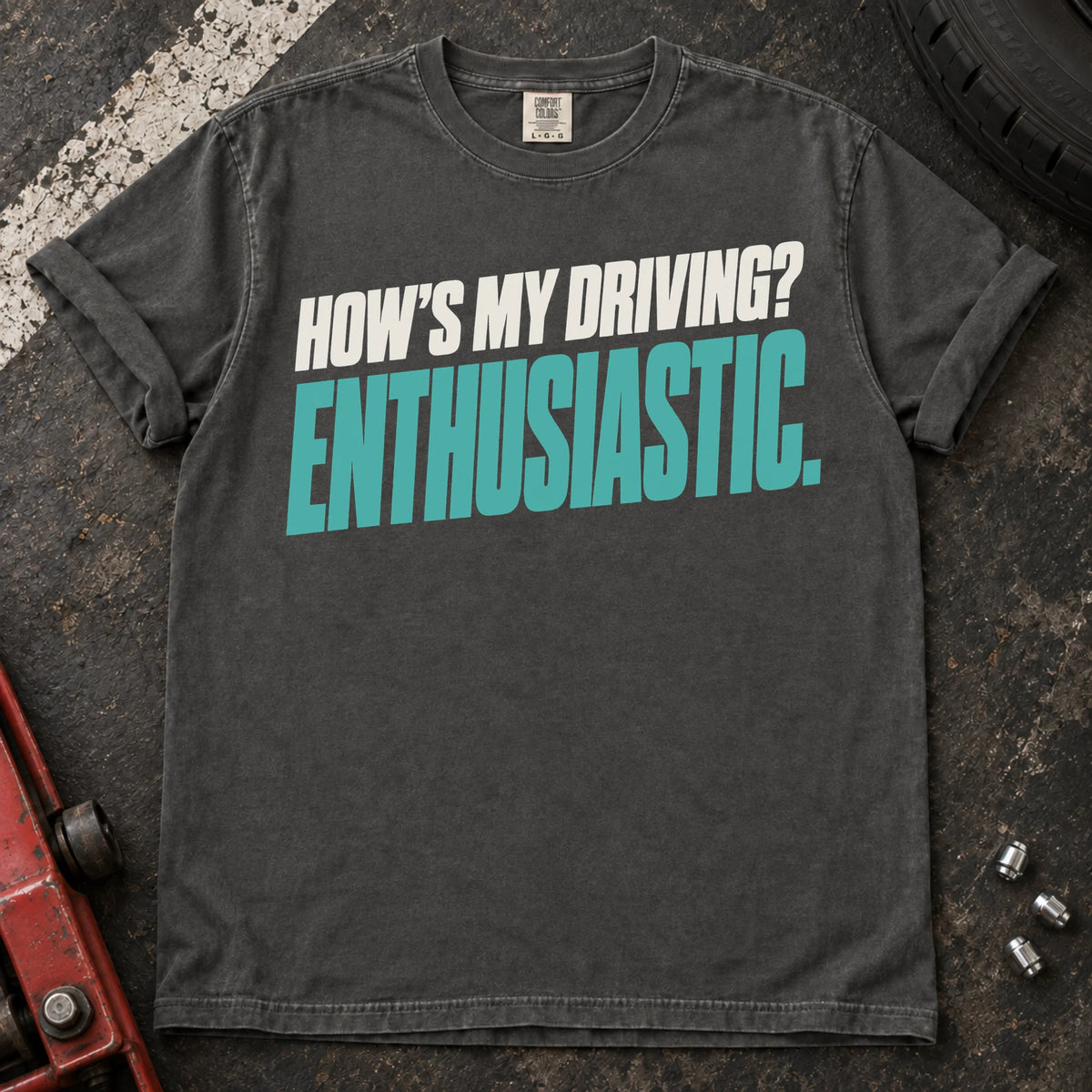 Pepper car enthusiast T-shirt. How's my driving? Enthusiastic. Bold lettering for the self-aware car lover.