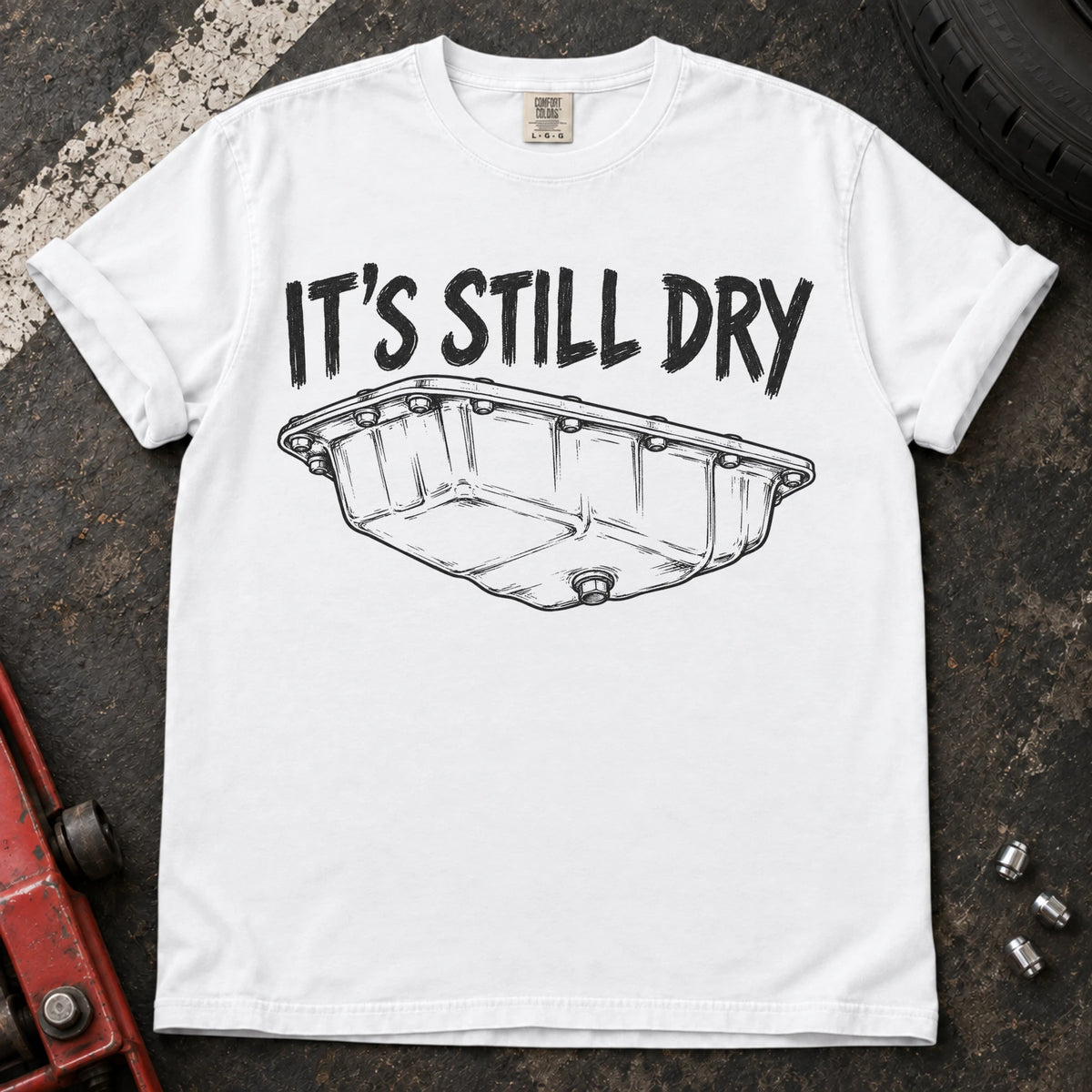 White car enthusiast T-shirt. An oil-pan illustration makes it's still dry a cautious automotive joke.