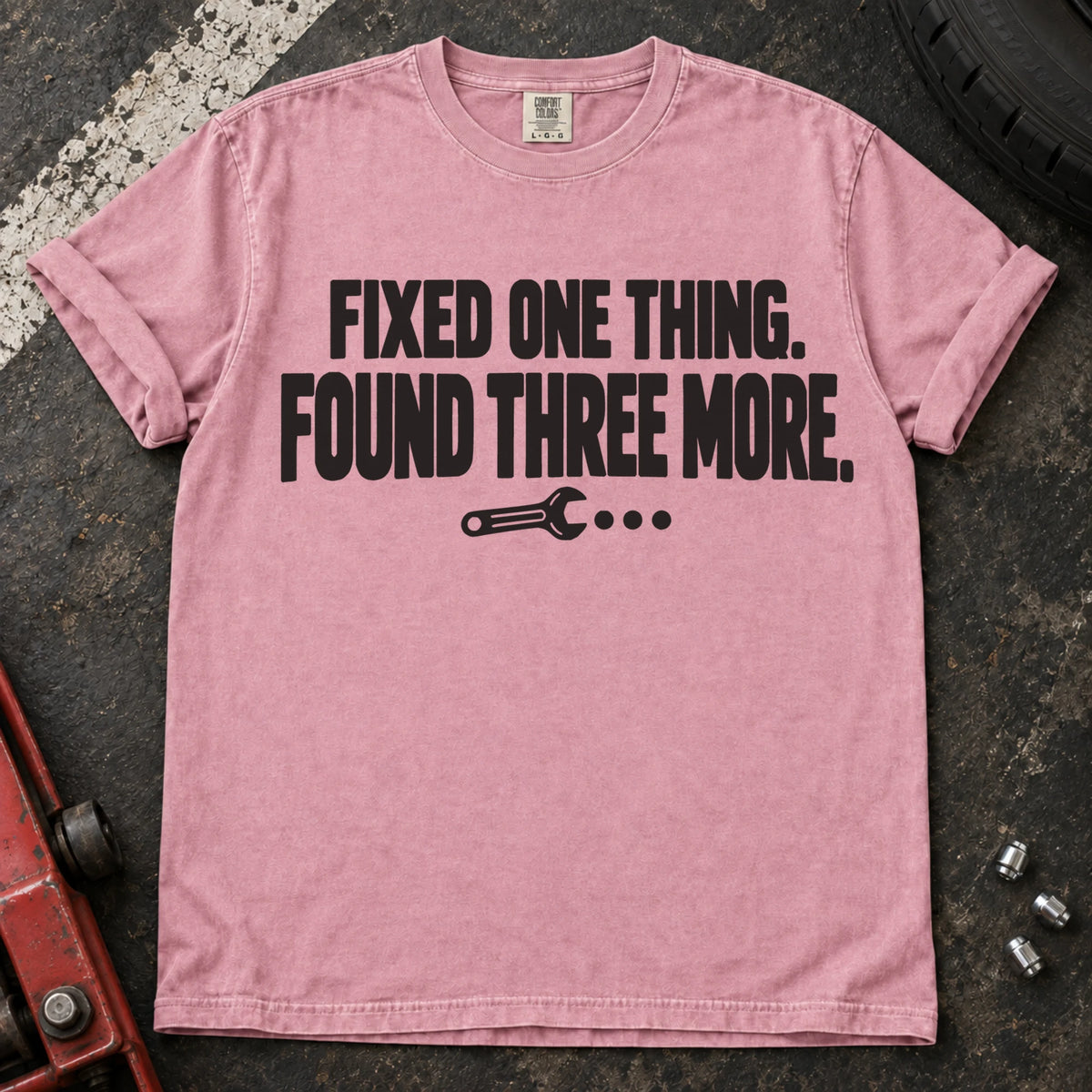 Blossom T-shirt reading 'Fixed one thing. Found three more' above a small wrench.