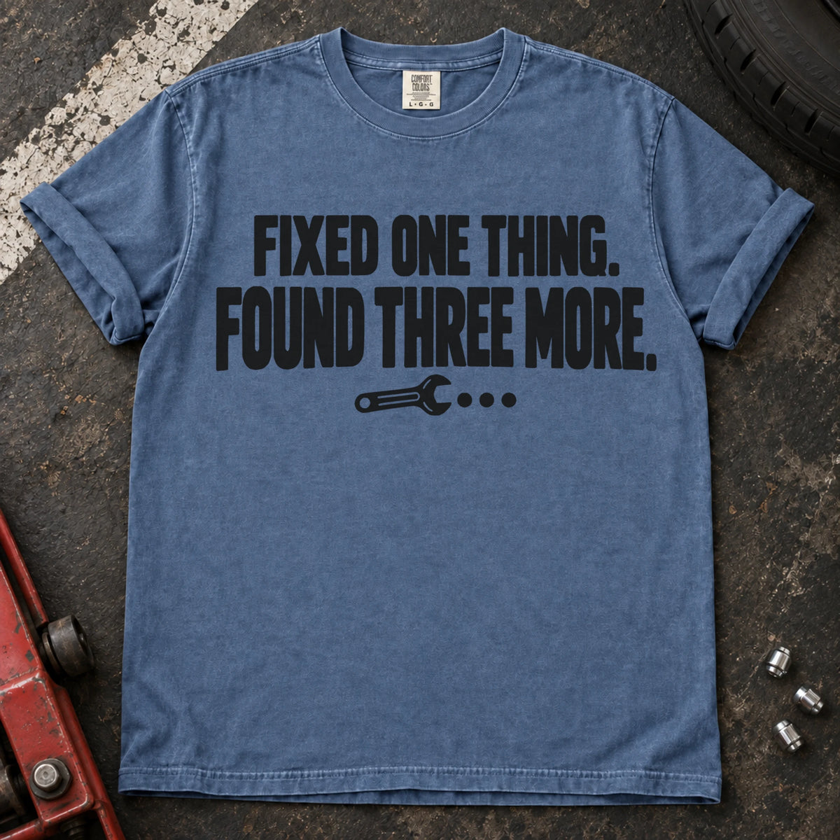 Blue Jean T-shirt reading 'Fixed one thing. Found three more' above a small wrench.
