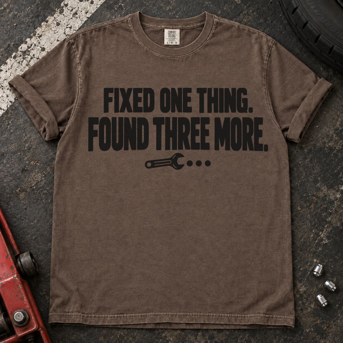 Espresso T-shirt reading 'Fixed one thing. Found three more' above a small wrench.