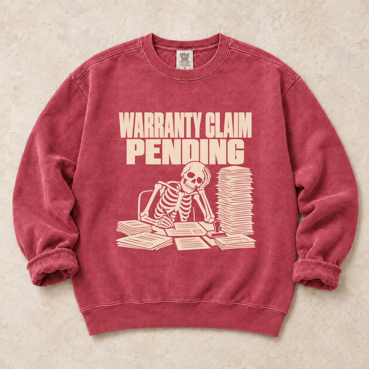 Crimson garment-dyed crewneck sweatshirt with Warranty Queue mechanic humor design