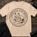 Natural gaming T-shirt. A curled-up cat on a controller pauses play for official cat duty.