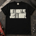 Black car enthusiast T-shirt. Not a money pit, just a hobby: clean typography for the car-owner budget.