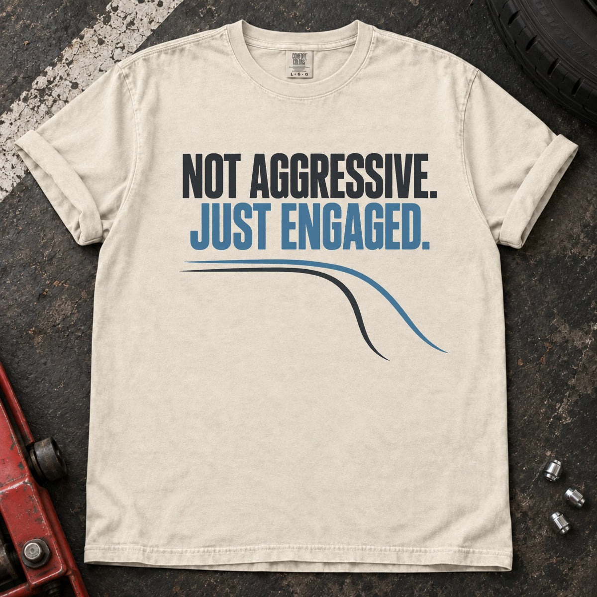 Ivory car enthusiast T-shirt. A cornering line explains not aggressive, just engaged.