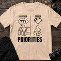 Natural gaming T-shirt. Partner confusion meets gamer affection in a two-panel priorities joke.