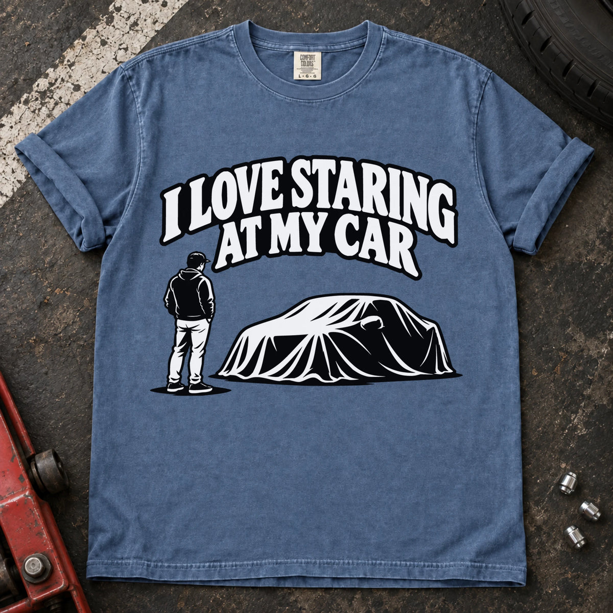 Blue Jean T-shirt showing a person beside a covered car under 'I love staring at my car'.