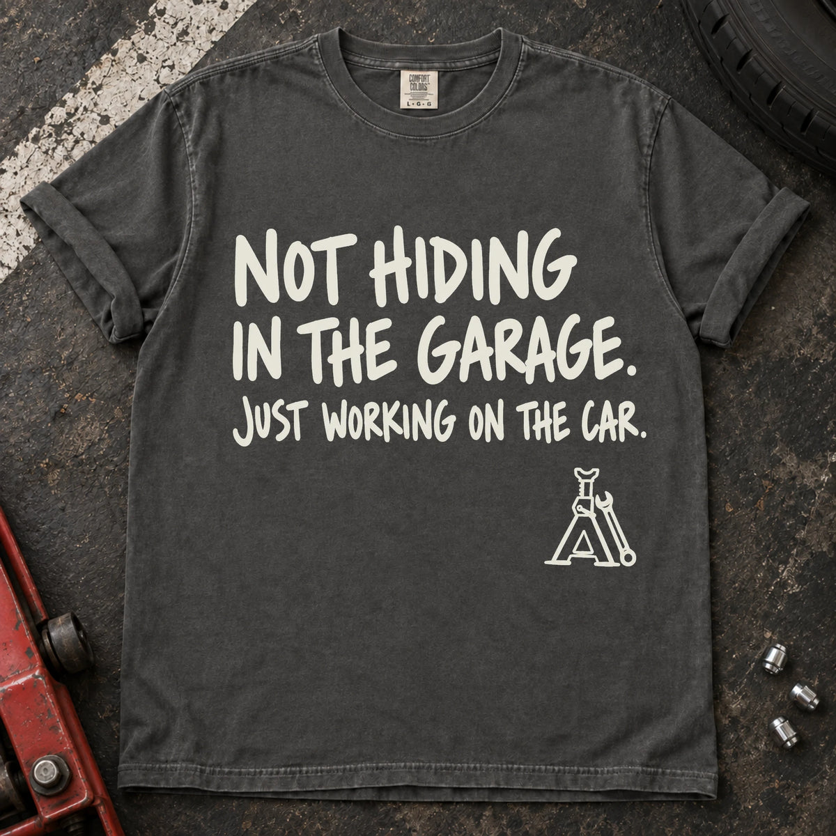 Pepper car enthusiast T-shirt. A jack stand backs not hiding in the garage, just working on the car.