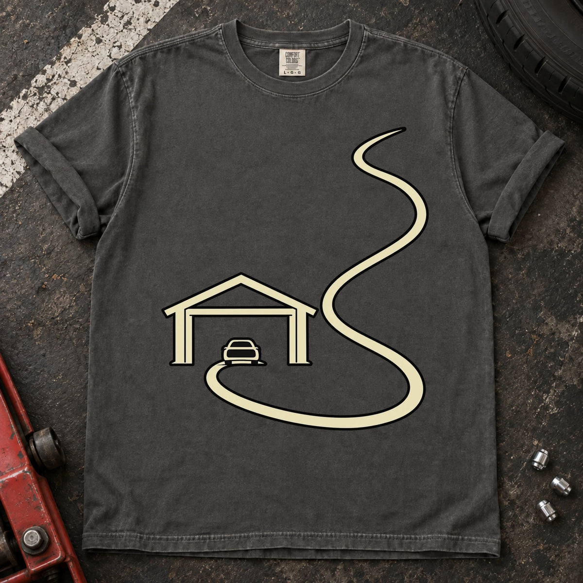 Pepper car enthusiast T-shirt. A minimal garage opens onto a long winding road.