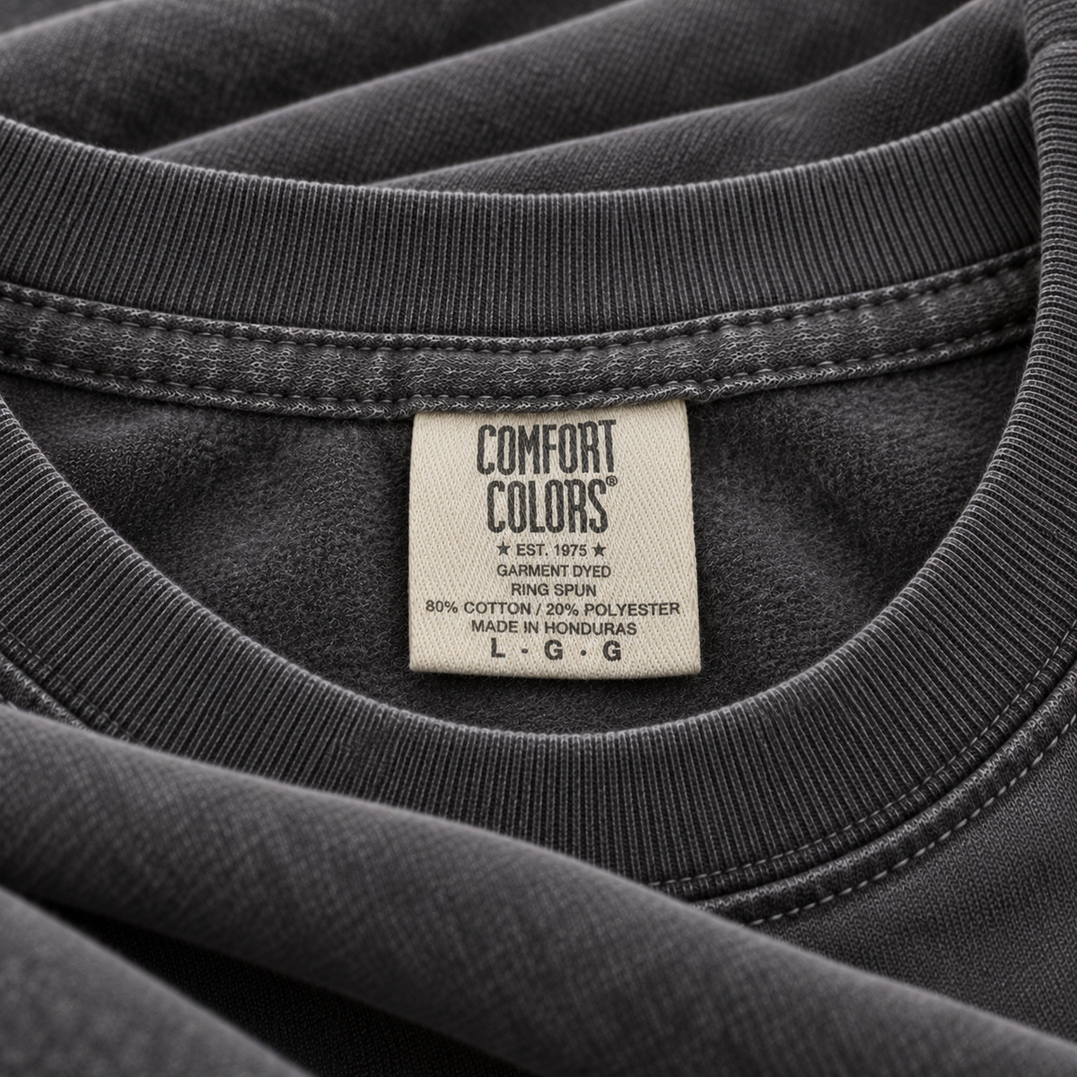 Comfort Colors 1566 sweatshirt in Pepper, close-up of the ribbed crewneck, fleece and woven neck label