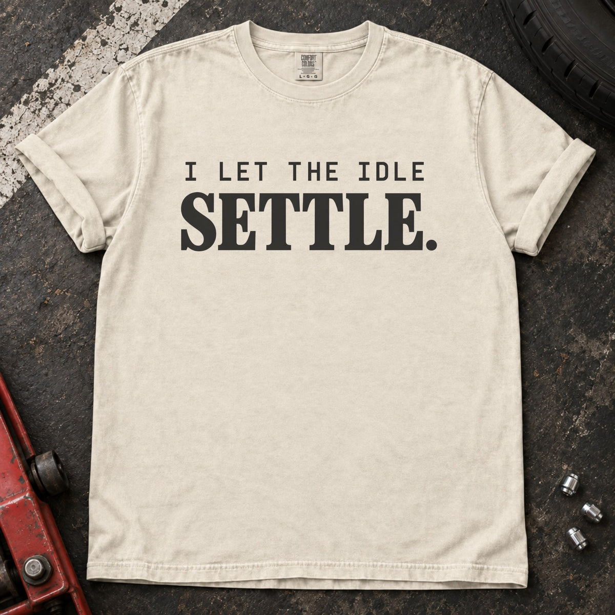 Ivory T-shirt with spaced lettering reading 'I let the idle settle'.