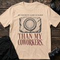 Natural gaming T-shirt. A worn controller-button icon marks a favorite game older than coworkers.