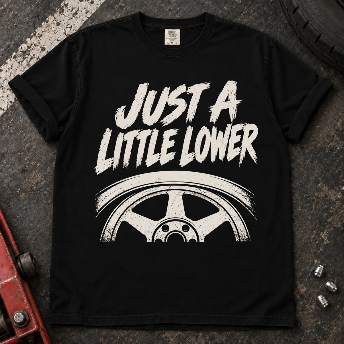 Black car enthusiast T-shirt. A wheel tucked under a fender accompanies just a little lower.
