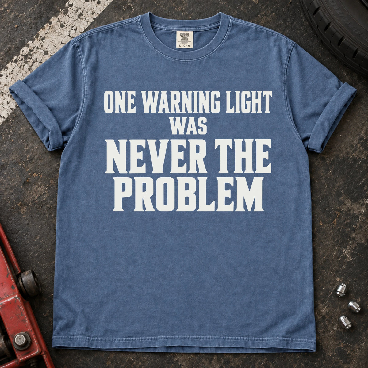 Blue Jean T-shirt with serif lettering reading 'One warning light was never the problem'.