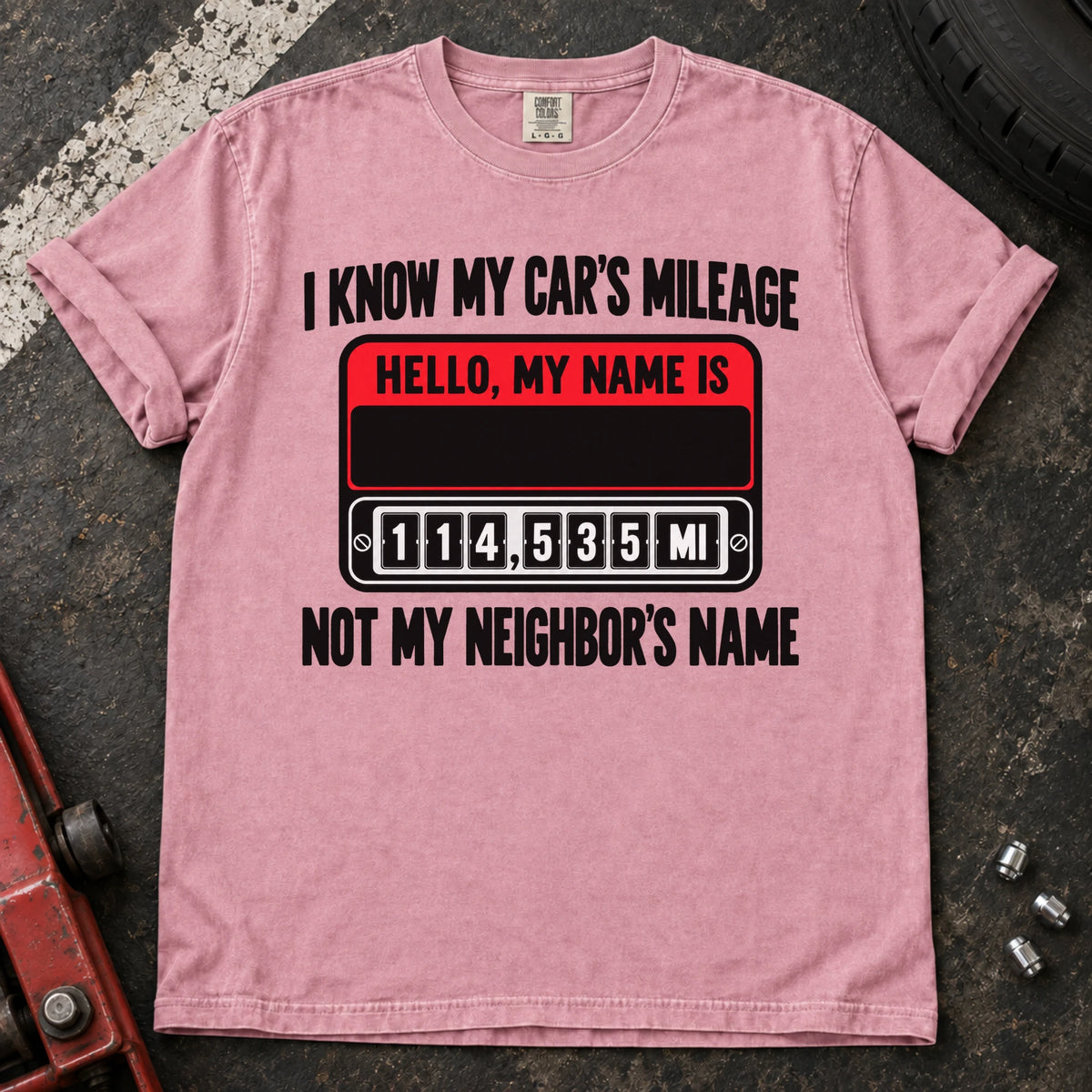 Blossom T-shirt showing a name badge and odometer with 'I know my car's mileage, not my neighbor's name'.