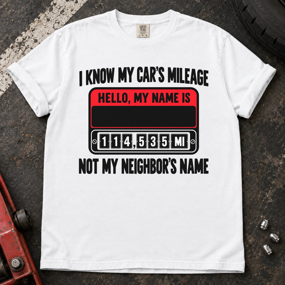 White T-shirt showing a name badge and odometer with 'I know my car's mileage, not my neighbor's name'.