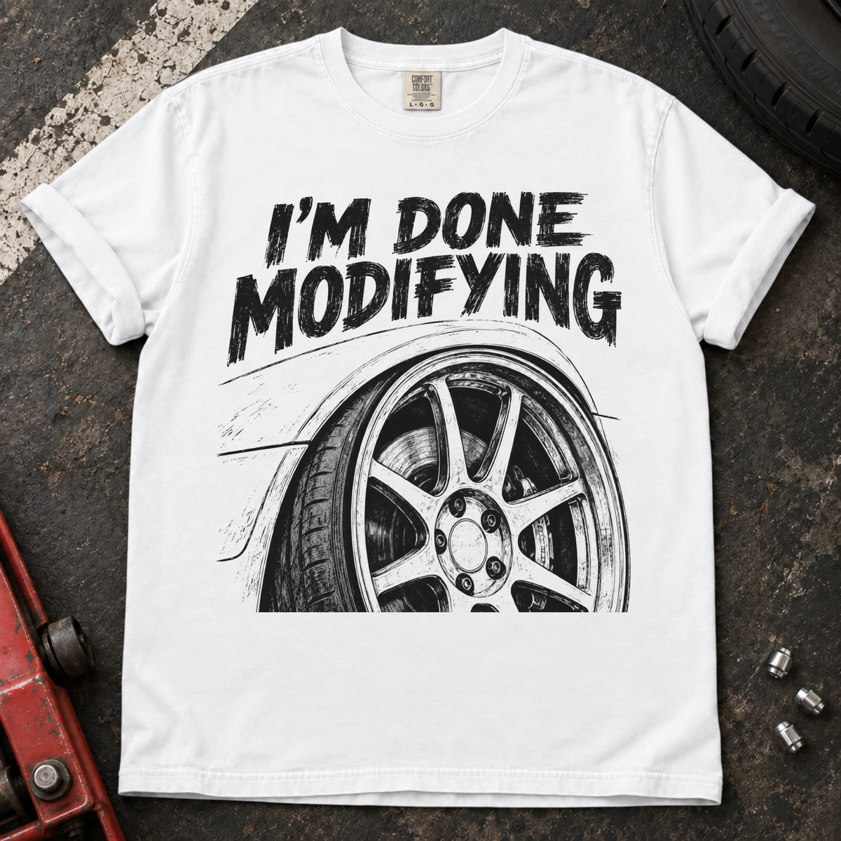 White car enthusiast T-shirt. A modified wheel sits under the familiar promise, I'm done modifying.