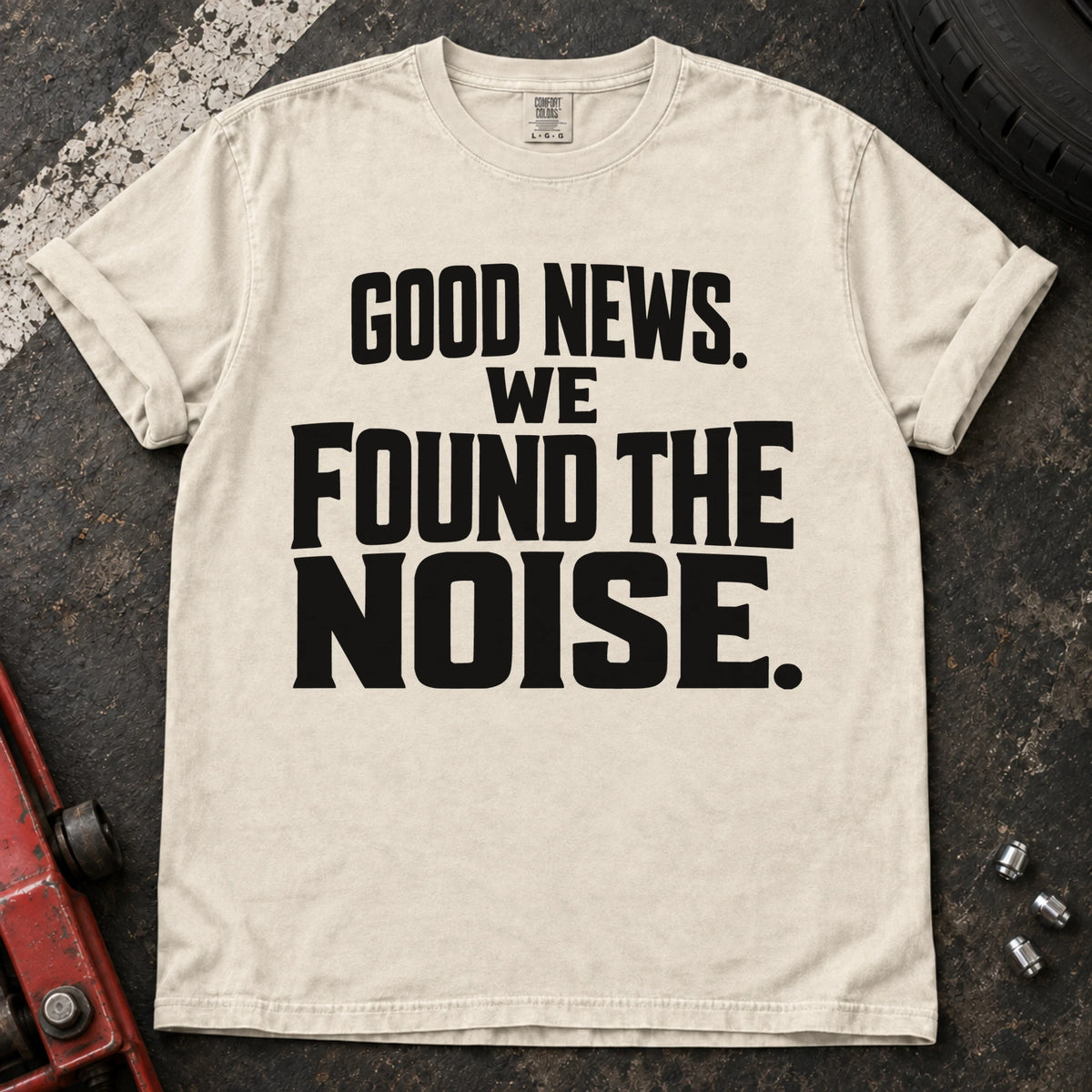 Ivory T-shirt with bold stacked lettering reading 'Good news. We found the noise'.