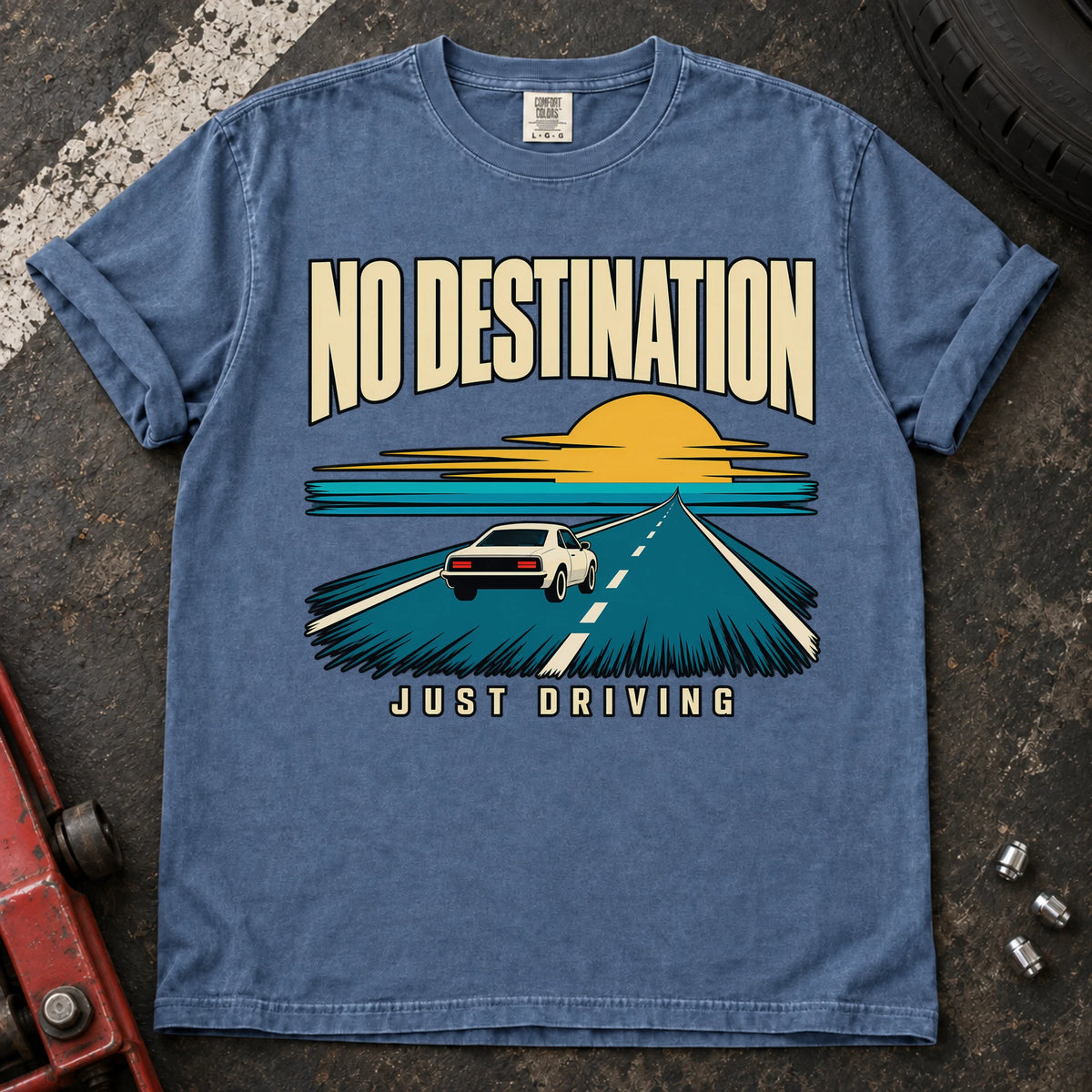 Blue Jean T-shirt showing a car on a road toward a sunset with 'No destination, just driving'.
