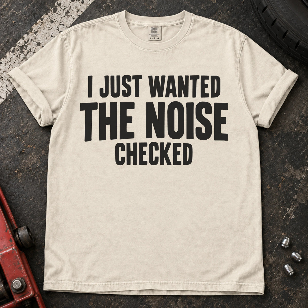 Ivory T-shirt with stacked black lettering reading 'I just wanted the noise checked'.