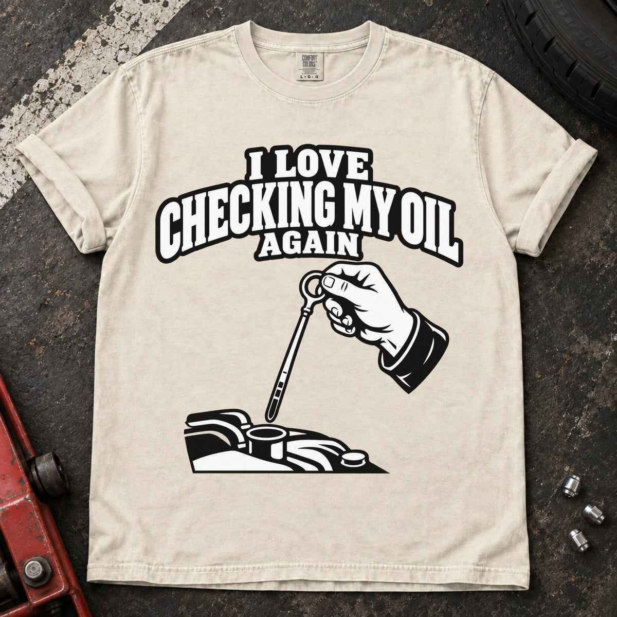 Ivory T-shirt showing a hand checking an engine dipstick under 'I love checking my oil again'.