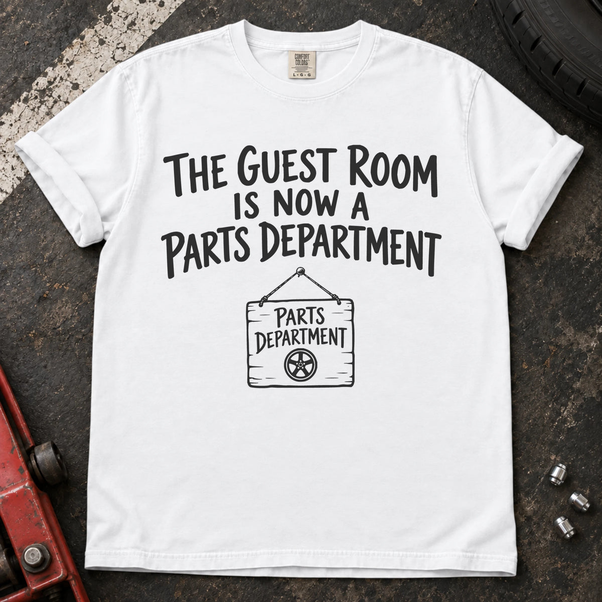 White T-shirt showing a Parts Department sign beneath 'The guest room is now a parts department'.