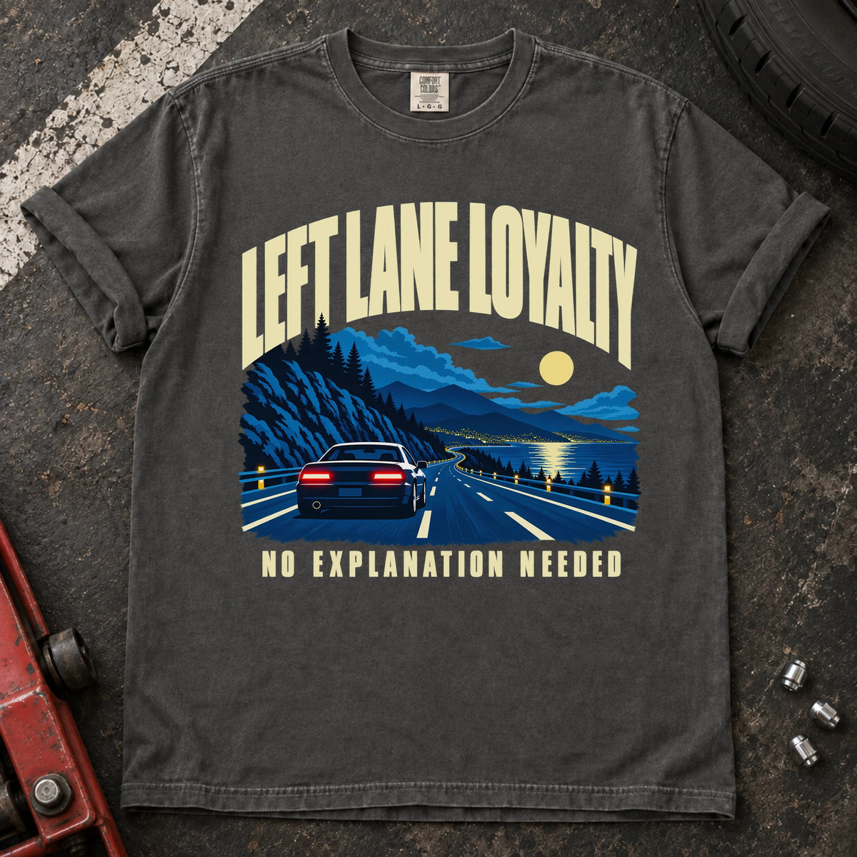Pepper T-shirt showing a car on a moonlit mountain road with 'Left lane loyalty. No explanation needed'.