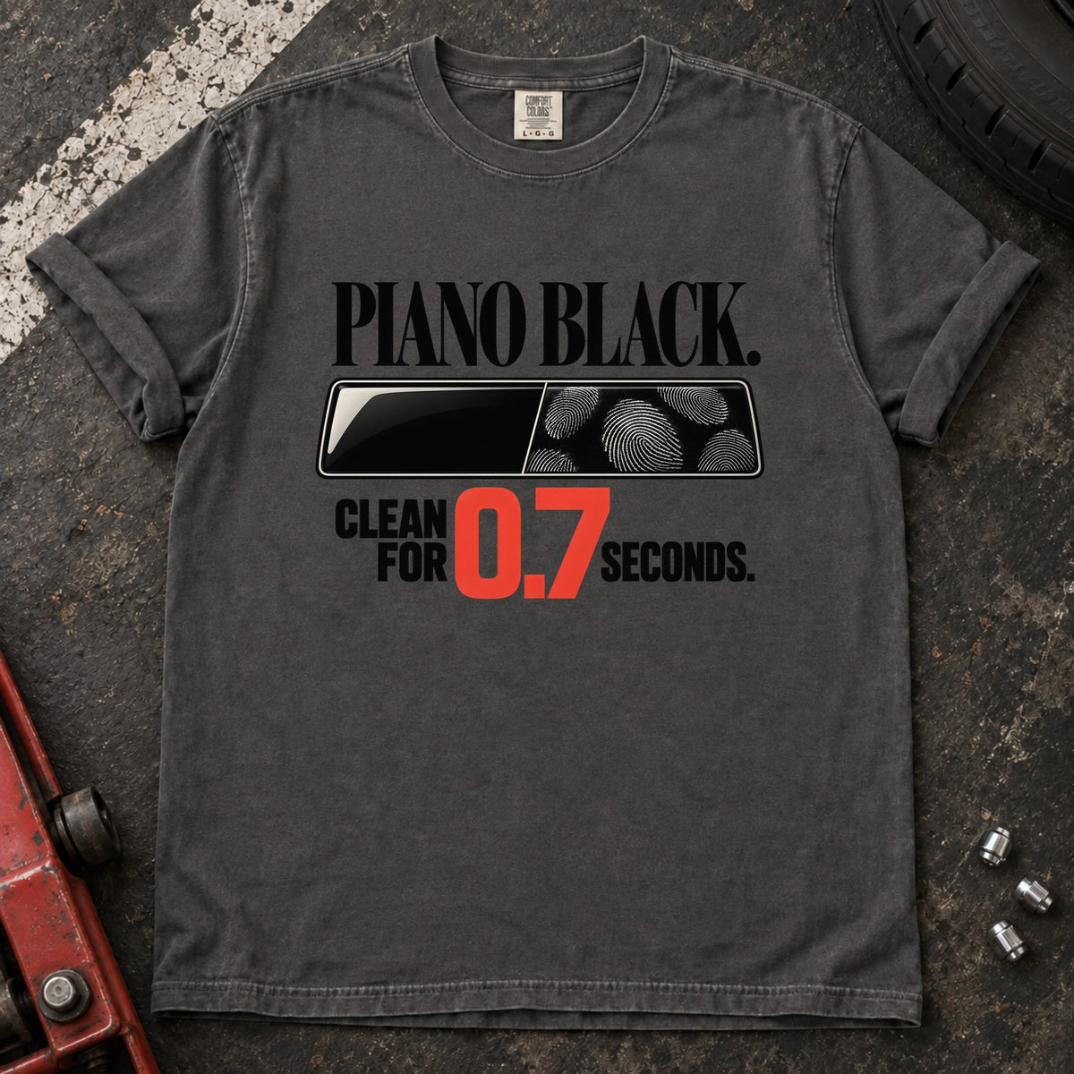 Pepper T-shirt showing fingerprints on a trim panel with 'Piano black. Clean for 0.7 seconds'.