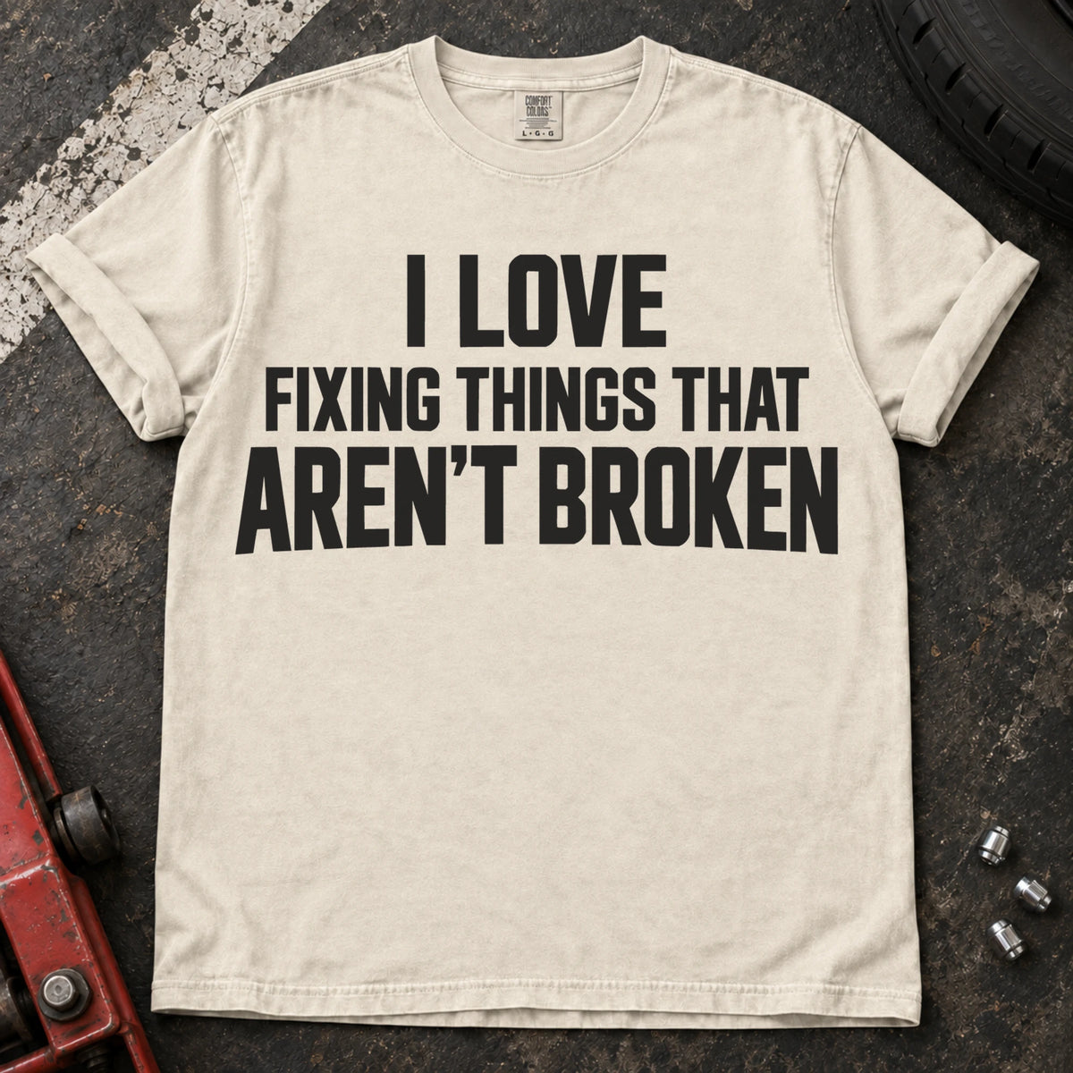 Ivory T-shirt with stacked lettering reading 'I love fixing things that aren't broken'.