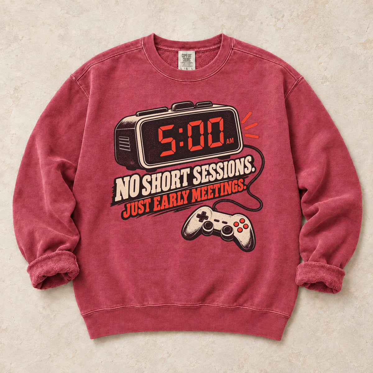 Crimson gaming sweatshirt. An early alarm and controller show there are no short sessions, just early meetings.