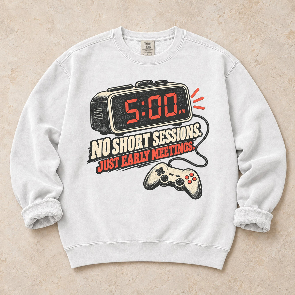 White gaming sweatshirt. An early alarm and controller show there are no short sessions, just early meetings.