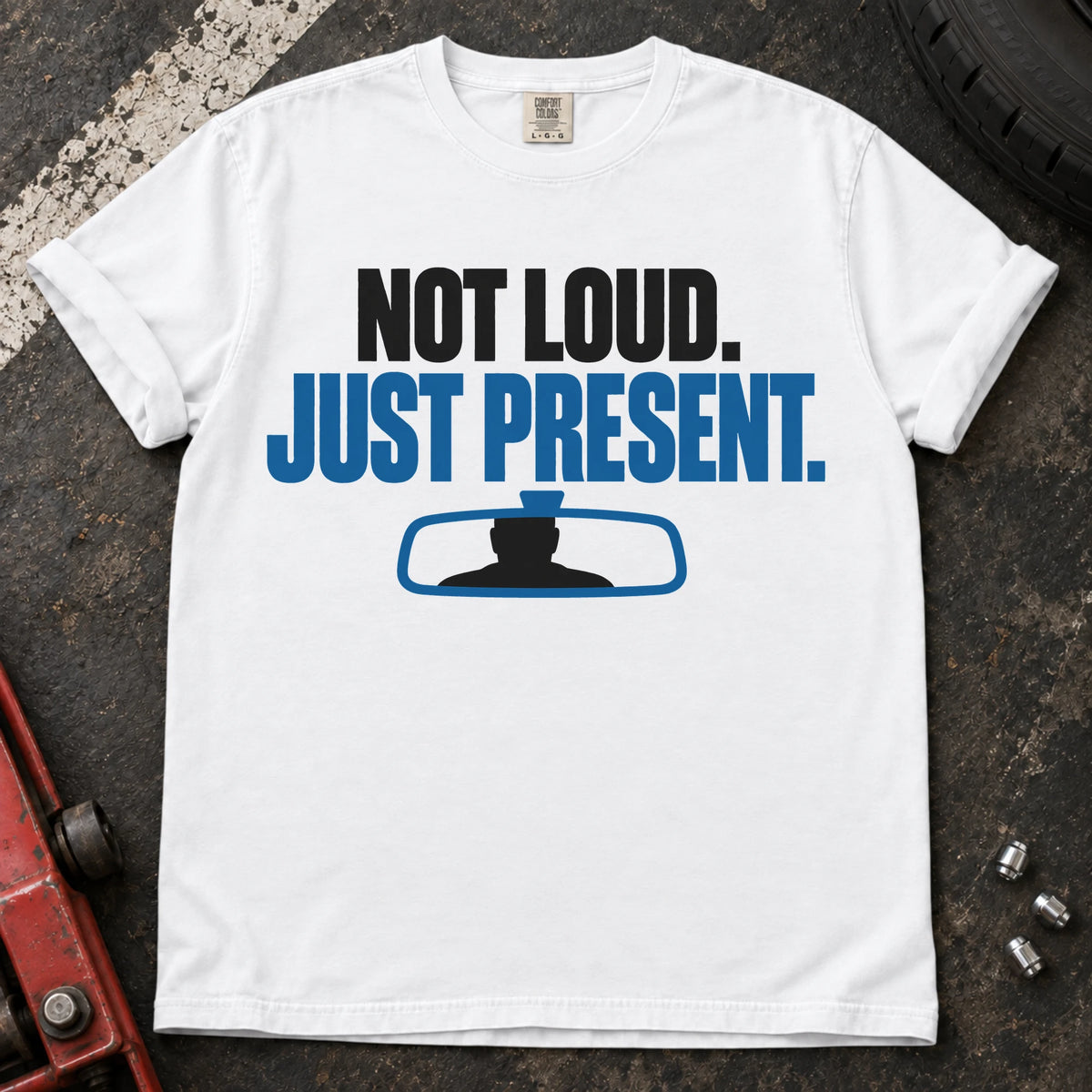 White car enthusiast T-shirt. A rearview mirror backs not loud, just present.