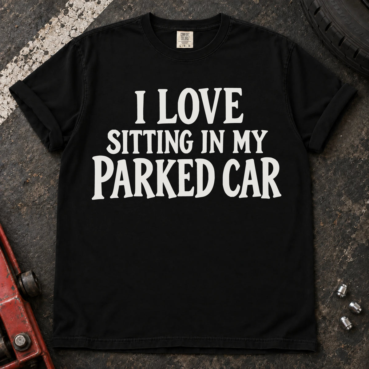 Black T-shirt with serif lettering reading 'I love sitting in my parked car'.